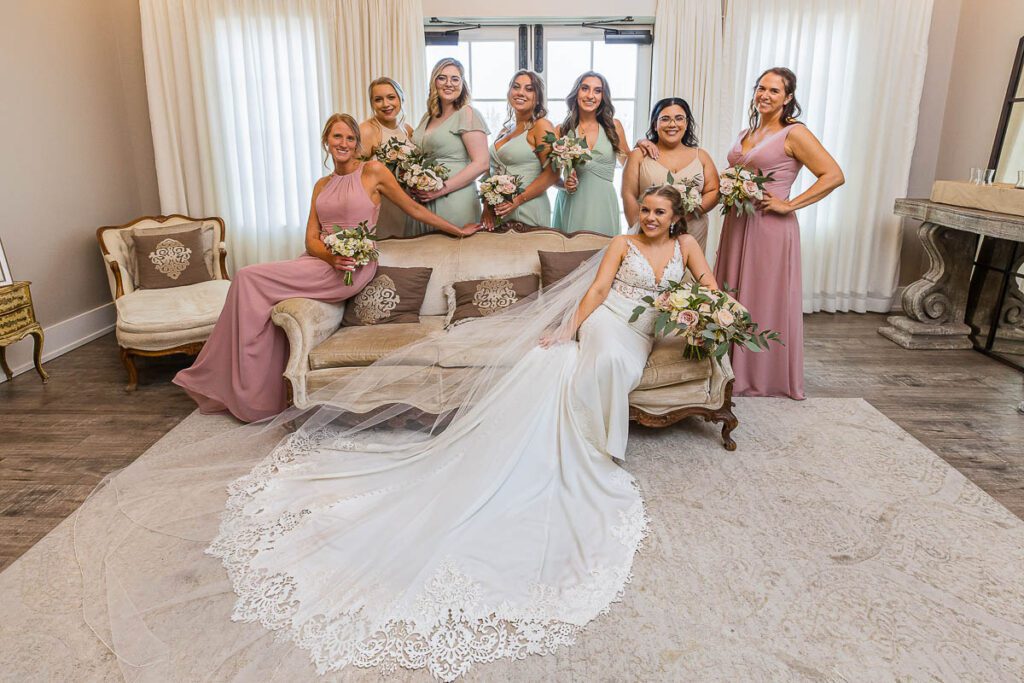 Bride sitting on sofa and posing with her bridesmaid