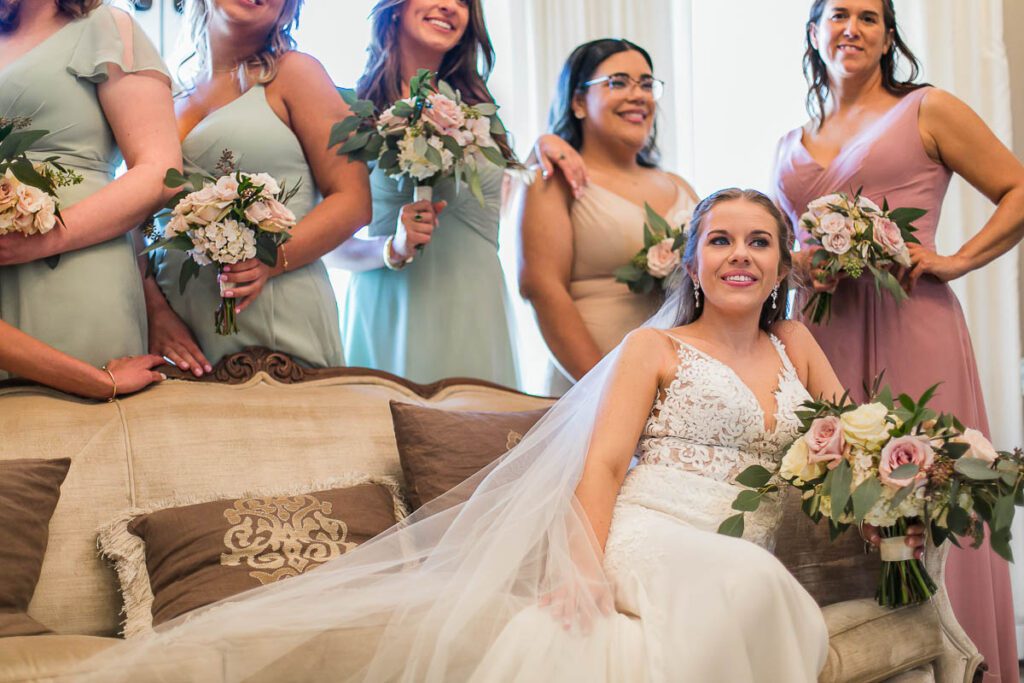 A close shot of Bride sitting on sofa and posing with her bridesmaid