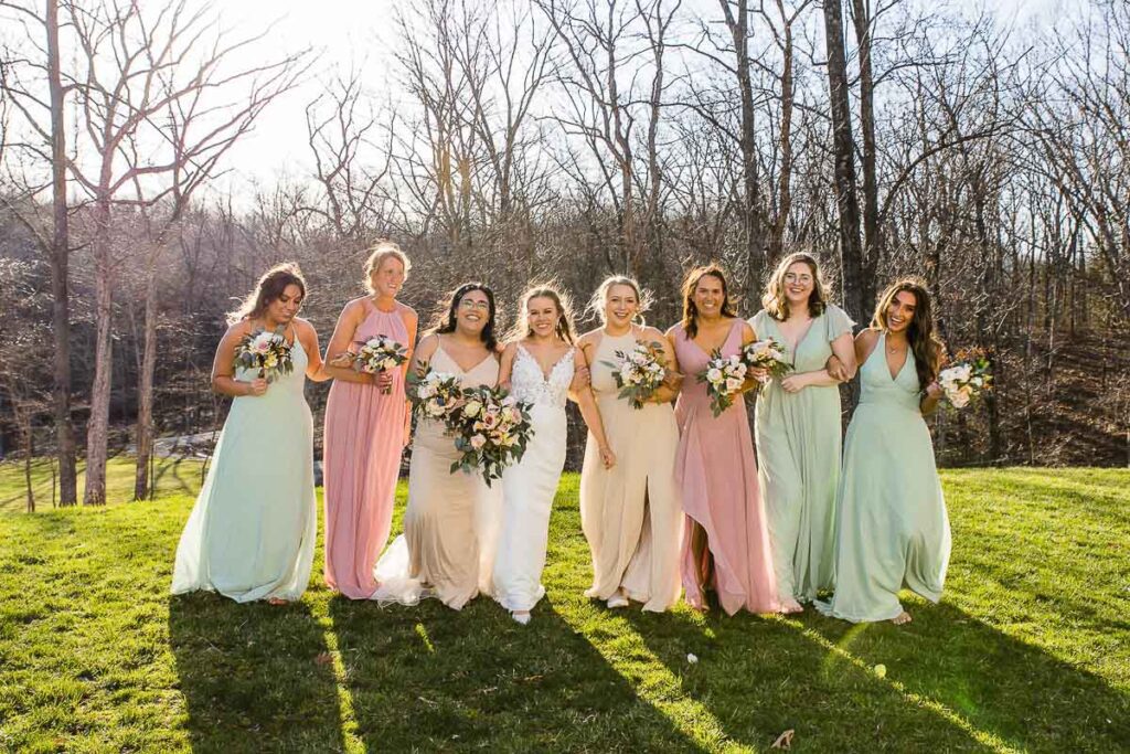 Bride posing with bridesmaid along with bouquets