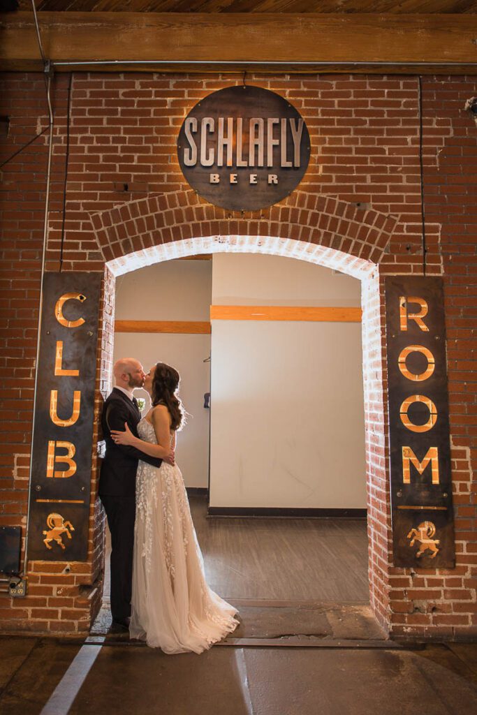 Bride and groom kissing each other and posing on the walls of club room