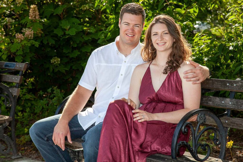 A long shot of Couple smiling and sitting on a bench in a park